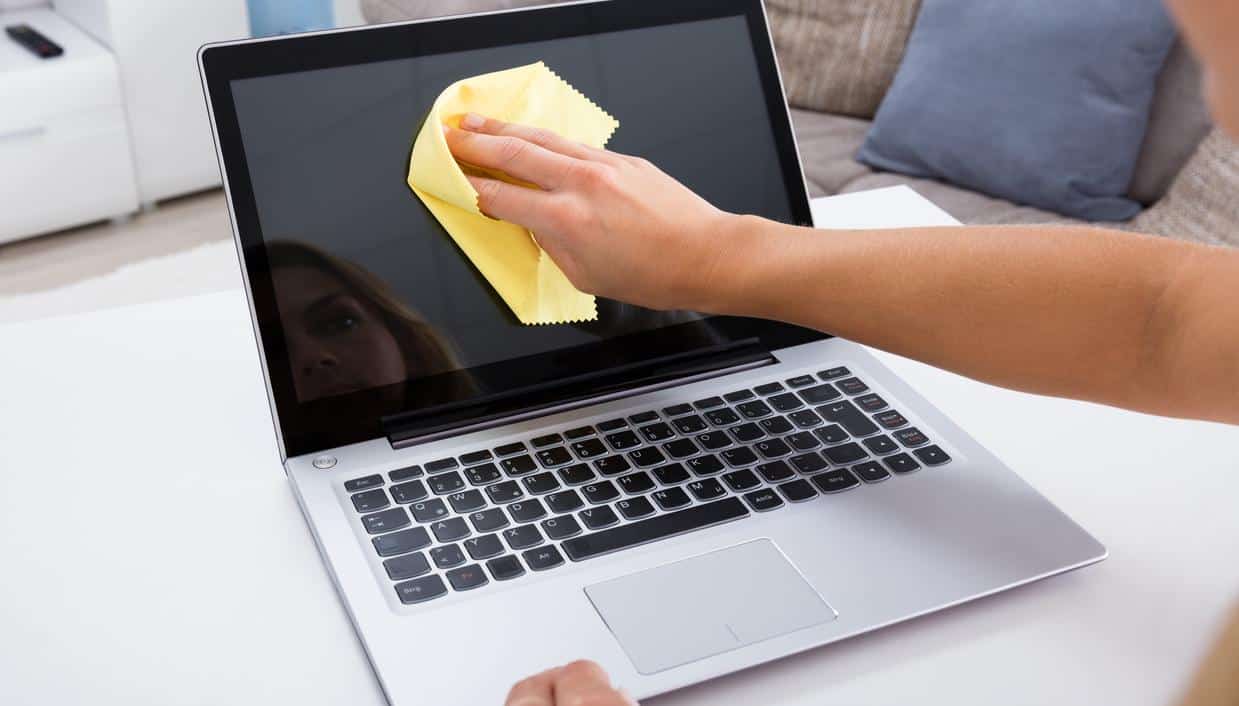 Close-up Of Woman Hand Cleaning Laptop Screen With Laptop At Home