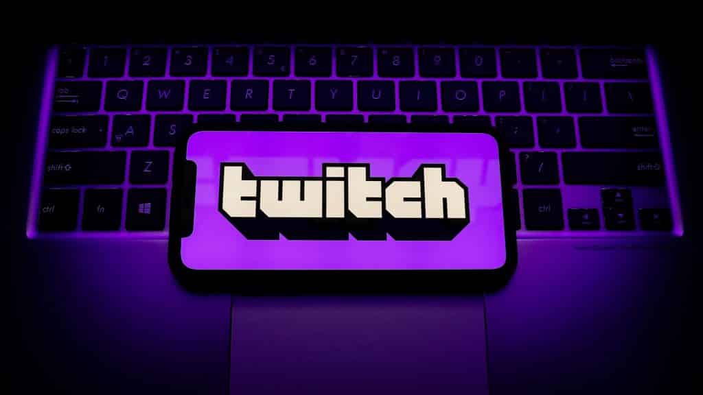 Image showing the Twitch logo on a phone screen, with the phone itself on a laptop keyboard.
